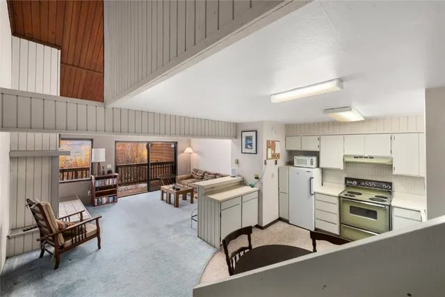 a living room with furniture and a refrigerator