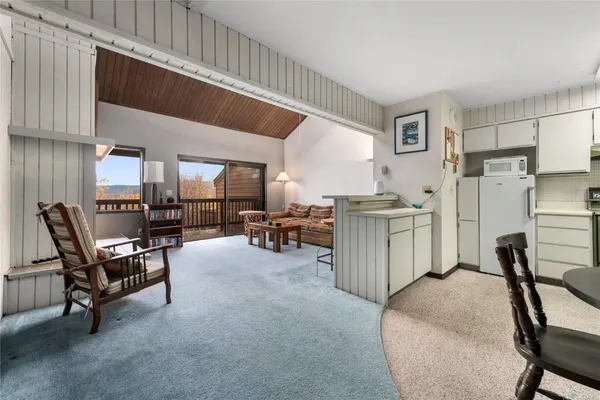 a kitchen with a dining table chairs and refrigerator