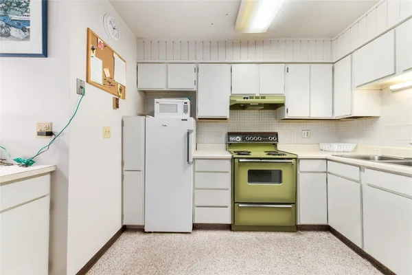 a kitchen with a stove a table and chairs in it