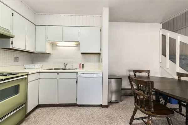 a view of a dining room with furniture and a kitchen