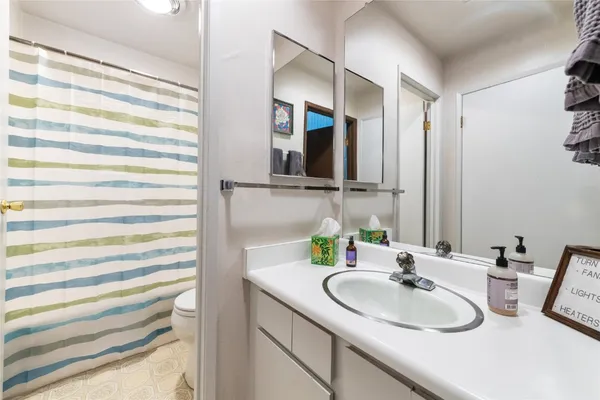 a bathroom with a sink and mirror with toilet