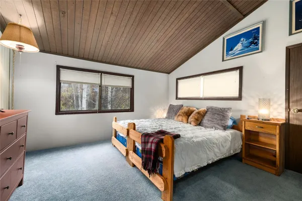 a bedroom with a bed dresser and flat screen tv