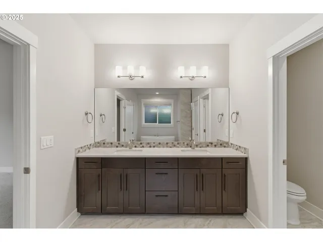a bathroom with a granite countertop sink a toilet and a mirror