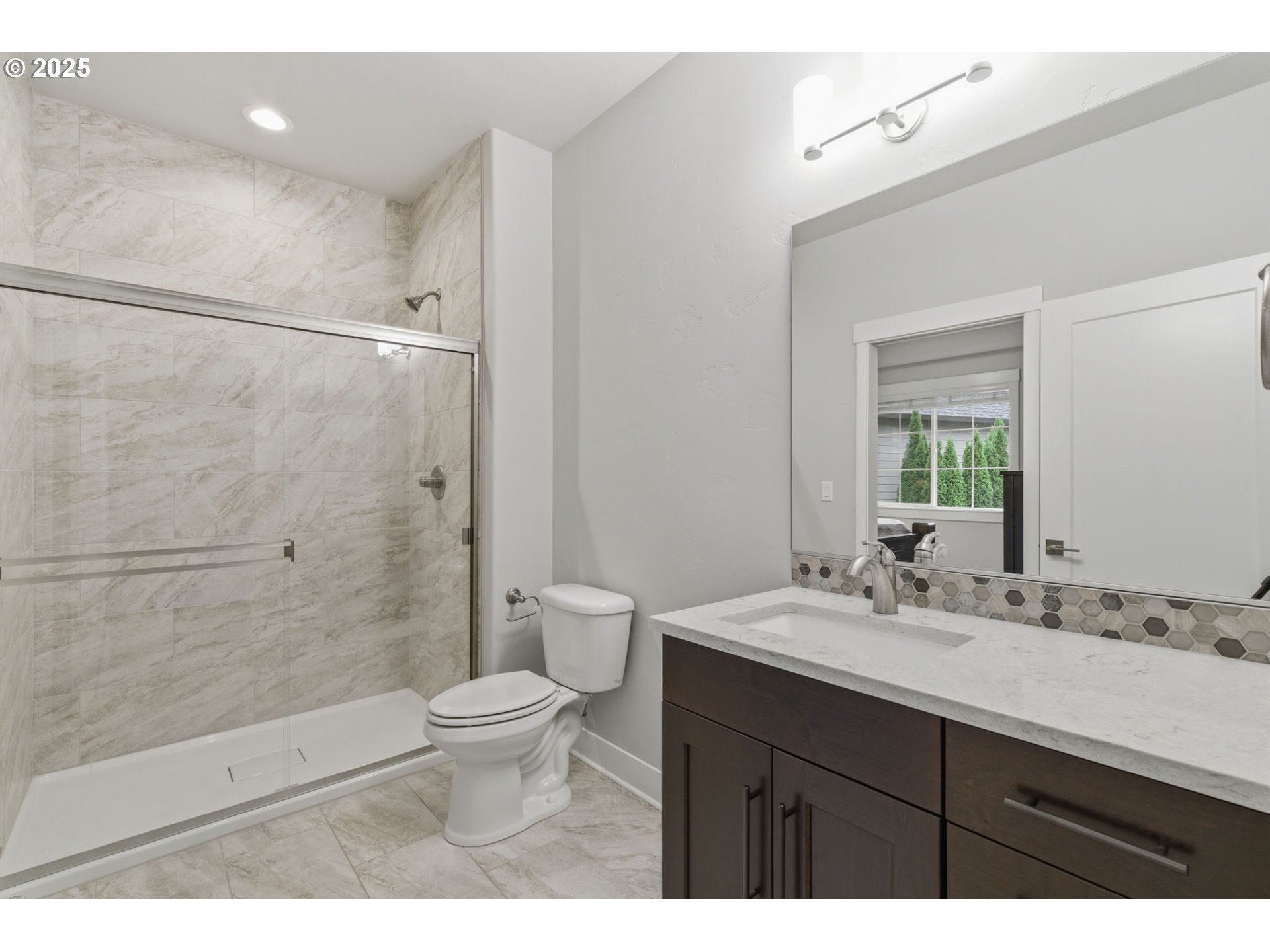 3228 Northwest Hood Court Camas, WA 98607 - Photo 17 of 28 a bathroom with a sink a toilet a mirror and shower