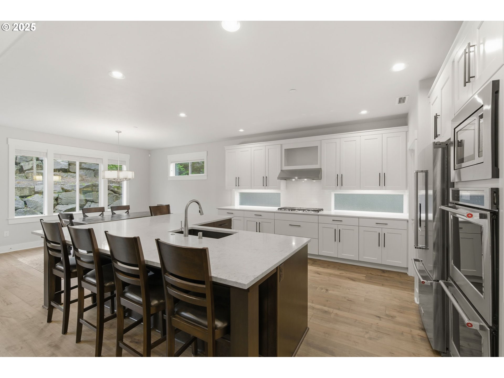 3228 Northwest Hood Court Camas, WA 98607 - Photo 4 of 28 a open dining room with stainless steel appliances kitchen island granite countertop a table chairs and a refrigerator