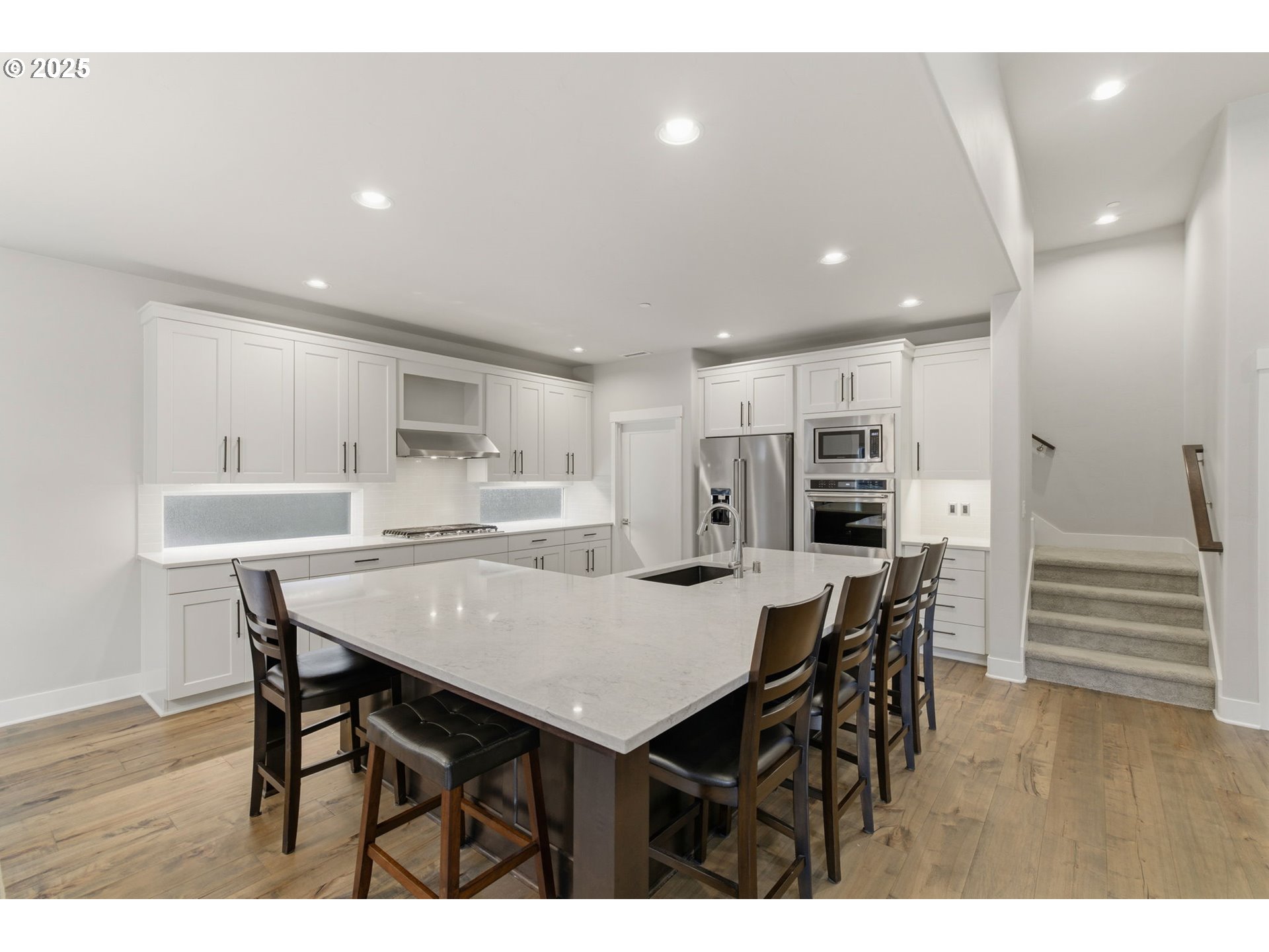 3228 Northwest Hood Court Camas, WA 98607 - Photo 5 of 28 a kitchen with stainless steel appliances kitchen island granite countertop a table chairs and wooden floor
