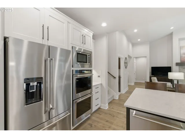 a kitchen with stainless steel appliances kitchen island a refrigerator sink and cabinets