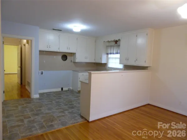 a kitchen with cabinets and wooden floor