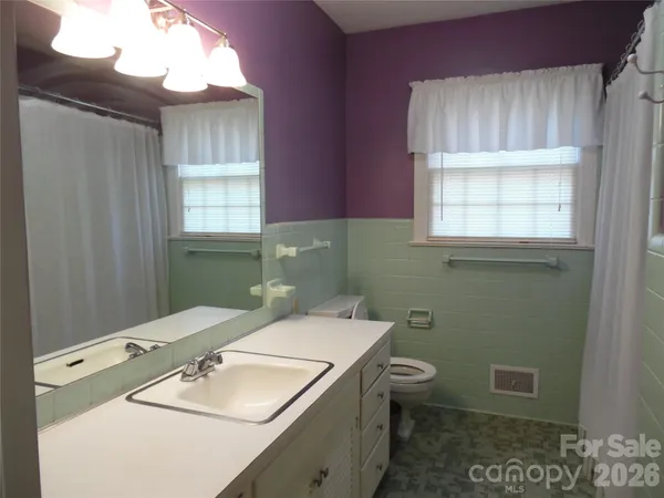a bathroom with a sink a toilet and window
