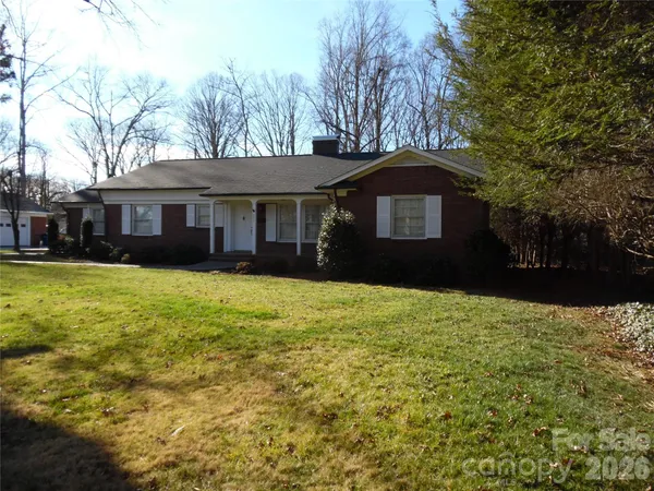 a front view of a house with a yard and trees