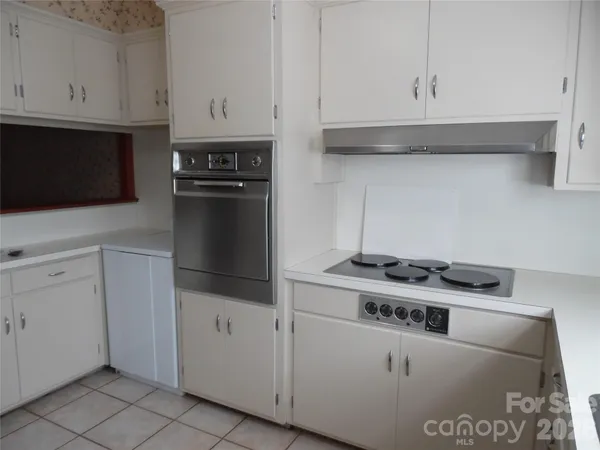 a kitchen with white cabinets and black appliances