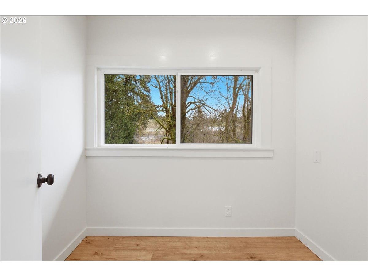 1313 Hining Road Winlock, WA 98596 - Photo 19 of 46 a view of an empty room with wooden floor and windows