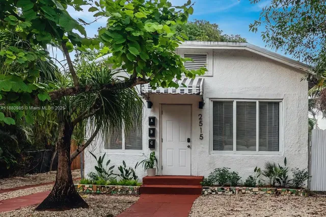 a front view of a house with potted plants