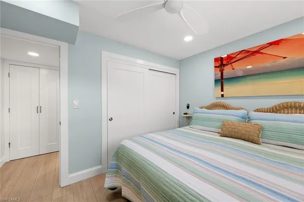 a bedroom with a bed wooden floor and window
