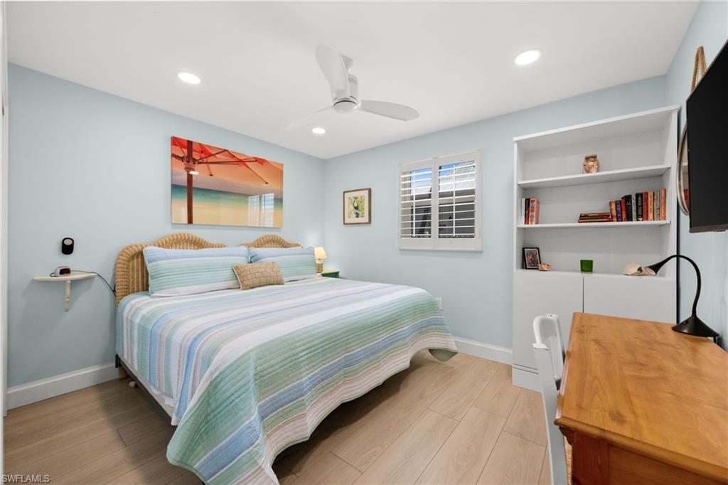 1021 3rd Street South, Unit 108 Naples, FL 34102 - Photo 18 of 31 a bedroom with a bed wooden floor and window