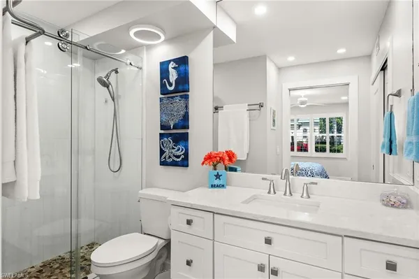 a bathroom with a sink vanity mirror and toilet