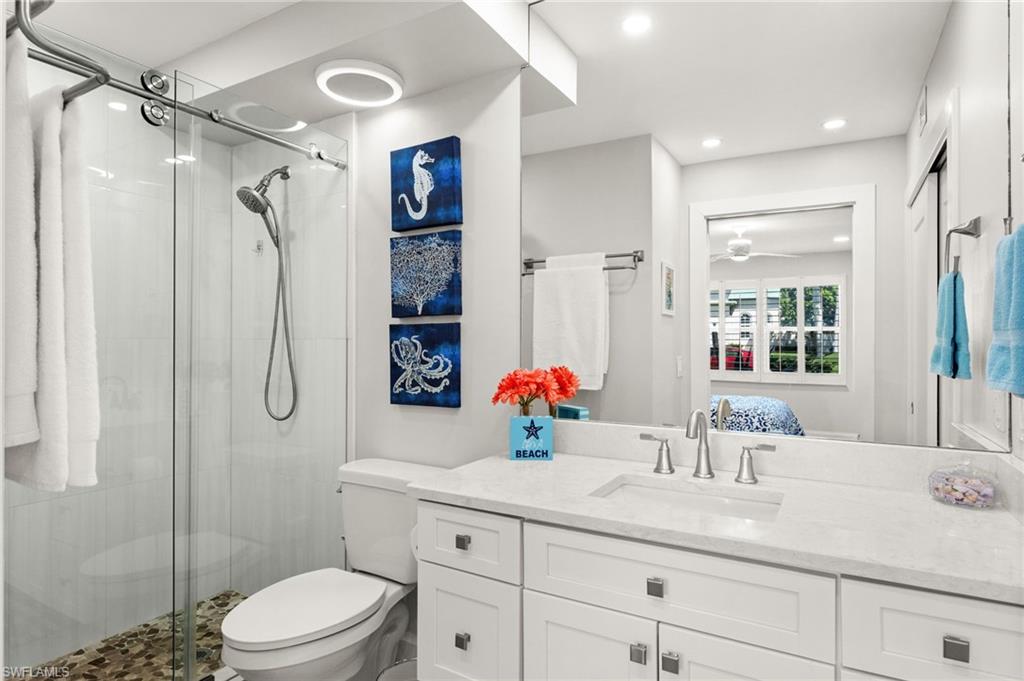 1021 3rd Street South, Unit 108 Naples, FL 34102 - Photo 19 of 31 a bathroom with a granite countertop sink toilet mirror and shower
