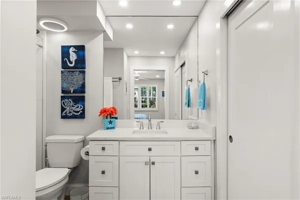 a bathroom with a granite countertop sink toilet a mirror a vanity and shower