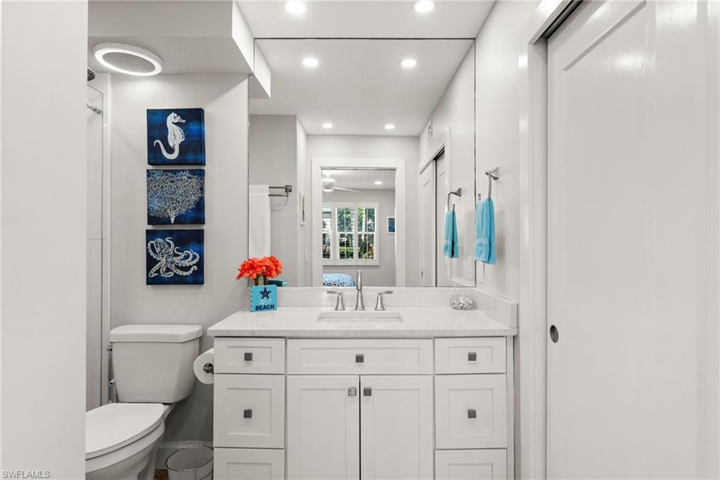 1021 3rd Street South, Unit 108 Naples, FL 34102 - Photo 20 of 31 a bathroom with a sink vanity mirror and toilet