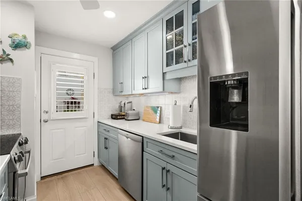 a kitchen with a sink a stove and a wooden floor
