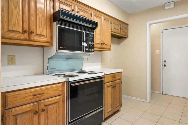 a kitchen with granite countertop a stove top oven microwave and cabinets