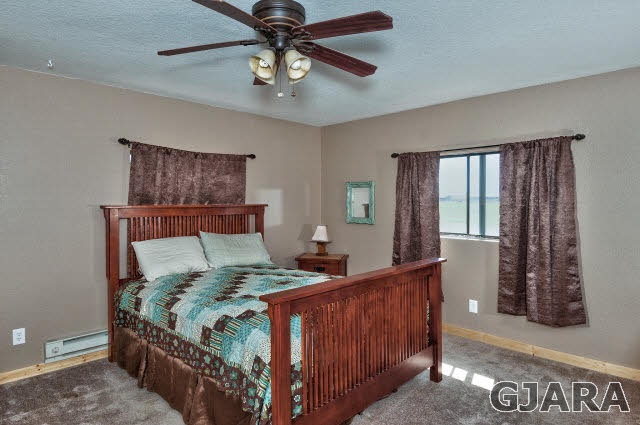 1190-18 18 1/2 Road Fruita, CO 81521 - Photo 16 of 35 a bedroom with a large bed and a chandelier