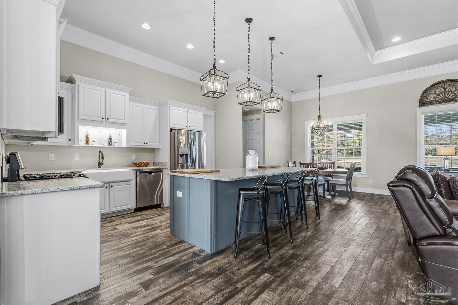 3550 Molino Road Molino, FL 32577 - Photo 19 of 68 a kitchen with stainless steel appliances granite countertop a stove top oven a sink dishwasher a dining table and chairs with wooden floor