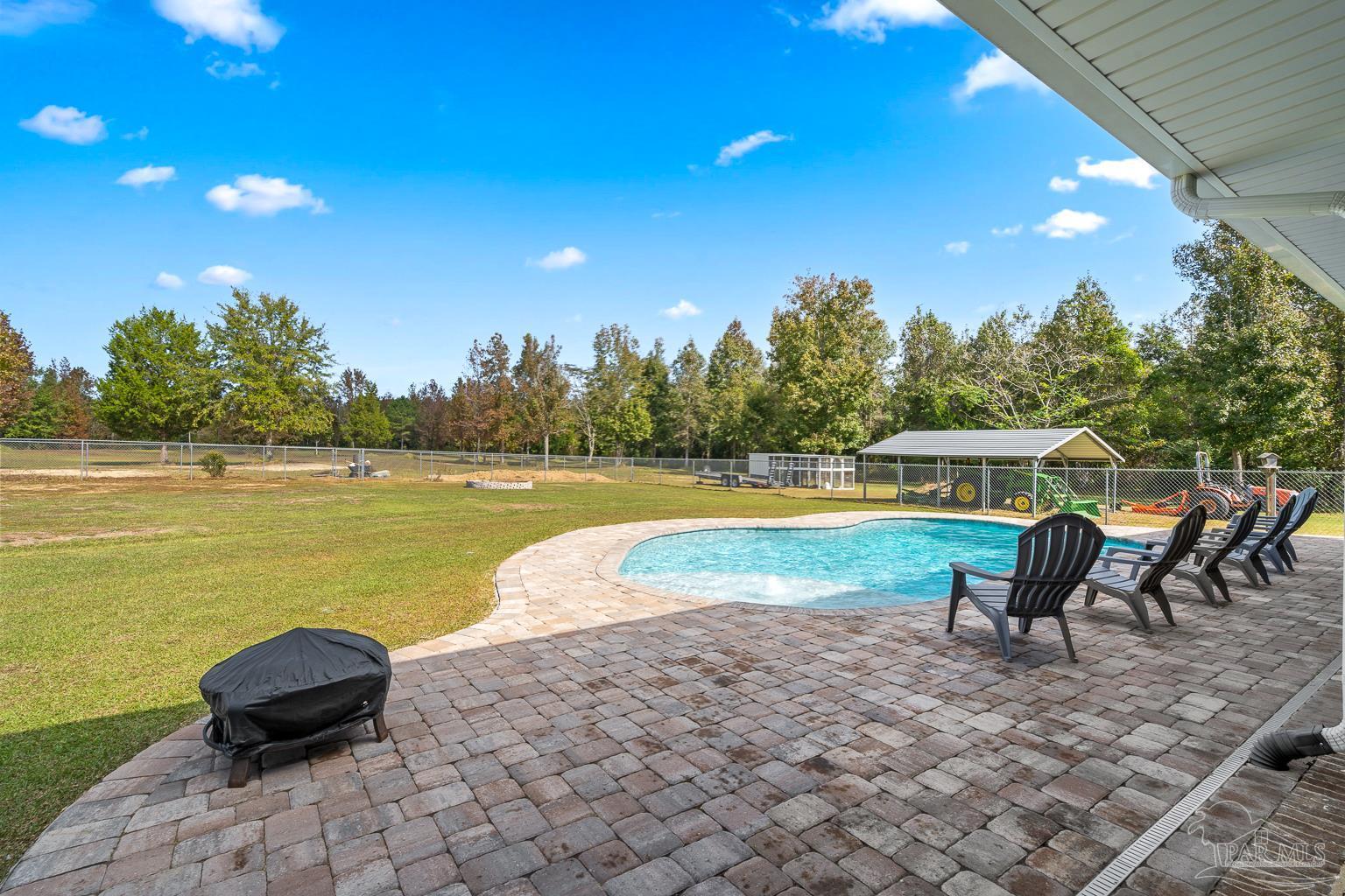 3550 Molino Road Molino, FL 32577 - Photo 50 of 68 a view of a swimming pool with a lounge chair and a lawn chairs