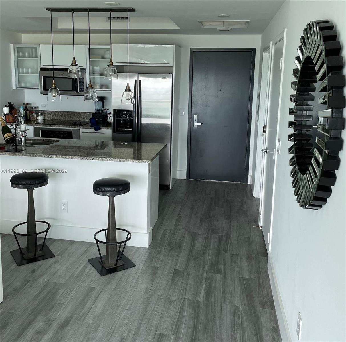 888 Biscayne Boulevard, Unit 1810 Miami, FL 33132 - Photo 19 of 28 a kitchen with stainless steel appliances a sink cabinets and wooden floor