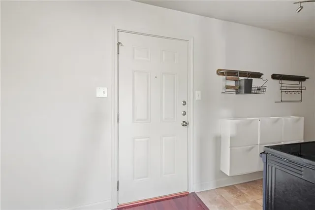 an empty room with wooden floor chandelier fan and windows