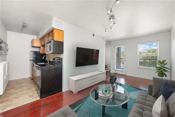 a living room with furniture flat screen tv and wooden floor