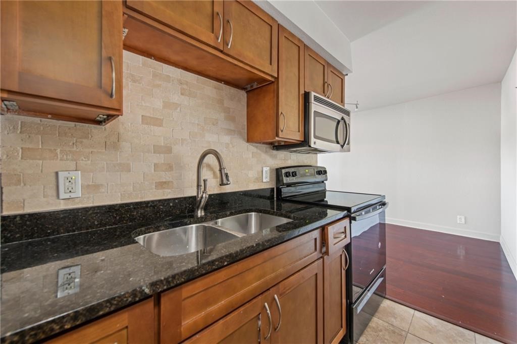 2020 South Congress Avenue, Unit 1216 Austin, TX 78704 - Photo 5 of 33 a kitchen with stainless steel appliances granite countertop a sink a stove and cabinets