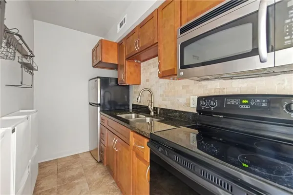 a kitchen with stainless steel appliances granite countertop a sink and a stove