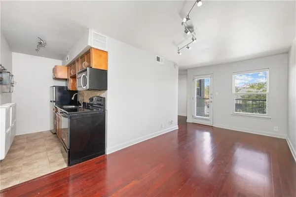 a view of a kitchen with furniture a ceiling fan and wooden floor