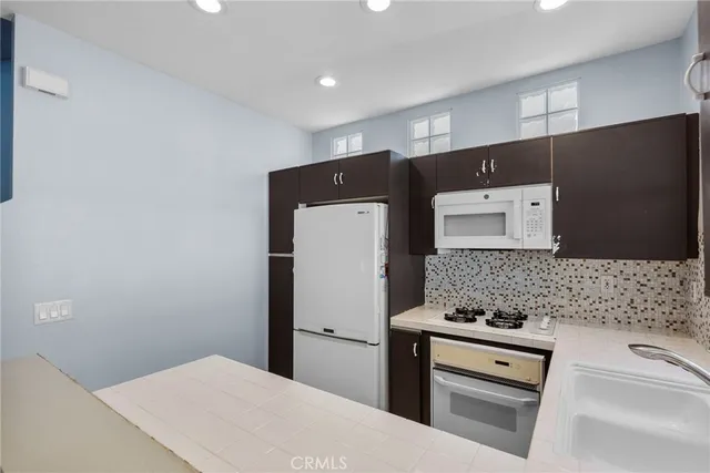 a kitchen with stainless steel appliances a refrigerator sink and stove