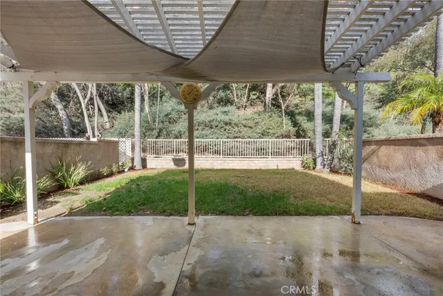 a view of a backyard with table and chairs under an umbrella