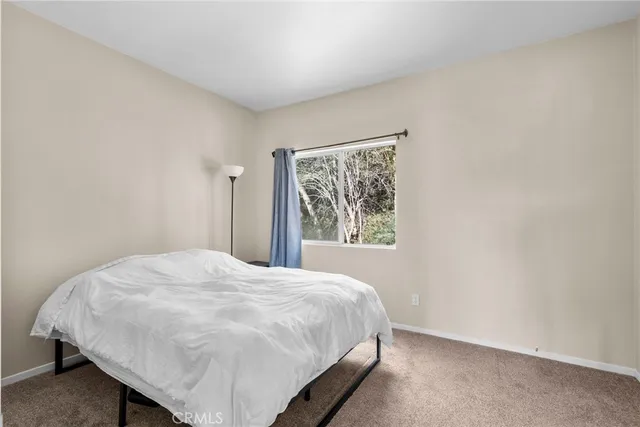 a bed sitting in a bedroom next to a window