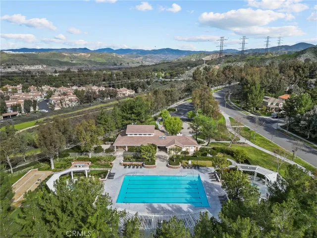 an aerial view of residential houses with outdoor space and trees
