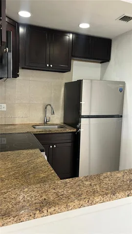 a kitchen with a refrigerator and a sink