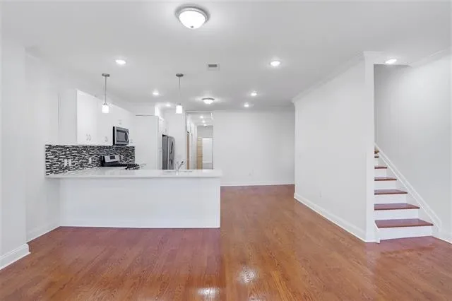 a view of kitchen with wooden floor and electronic appliances
