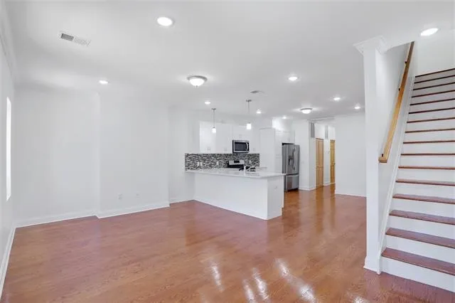 a view of kitchen with kitchen island white cabinets and stainless steel appliances