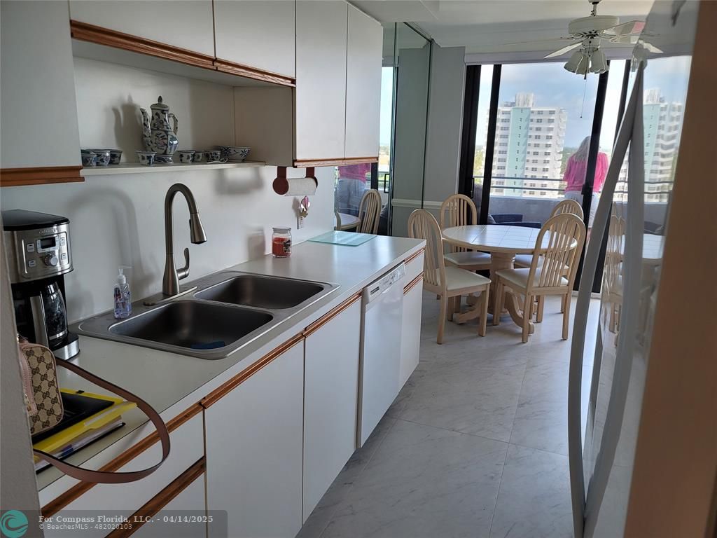 1500 North Ocean Boulevard, Unit 901 Pompano Beach, FL 33062 - Photo 11 of 19 a kitchen with kitchen island a stove a sink and a refrigerator