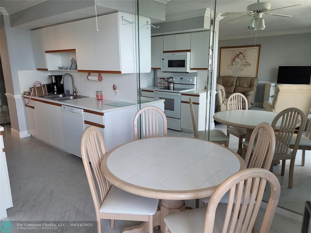 1500 North Ocean Boulevard, Unit 901 Pompano Beach, FL 33062 - Photo 13 of 19 a kitchen with stainless steel appliances a dining table and chairs