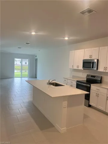 a kitchen with stainless steel appliances granite countertop a sink and a microwave