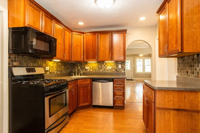 a kitchen with stainless steel appliances granite countertop a stove a refrigerator and a stove