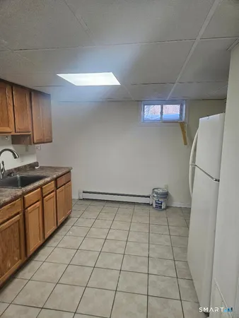 a kitchen with a sink a refrigerator and cabinets