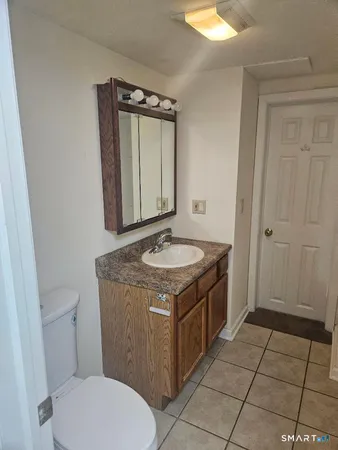 a bathroom with a granite countertop sink a toilet and a mirror