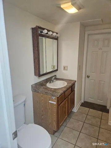 a bathroom with a granite countertop sink a toilet and a mirror