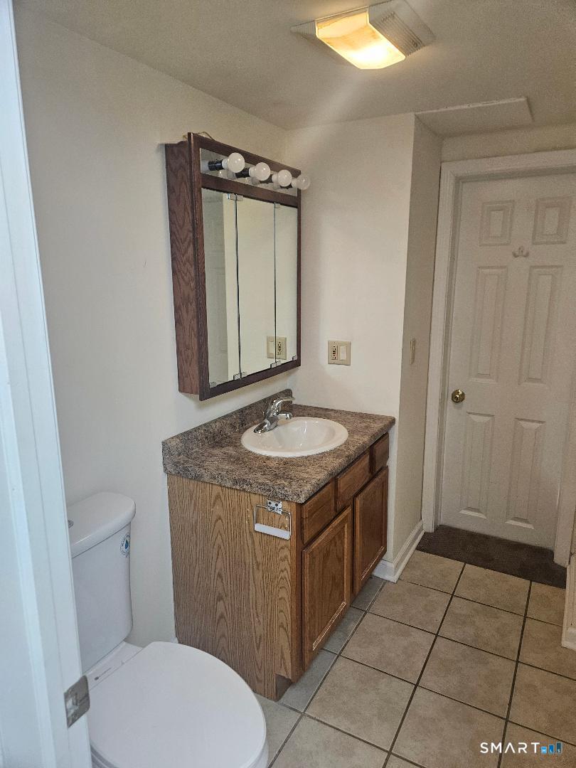 1129 Southford Road Middlebury, CT 06762 - Photo 7 of 7 a bathroom with a granite countertop sink a toilet and a mirror