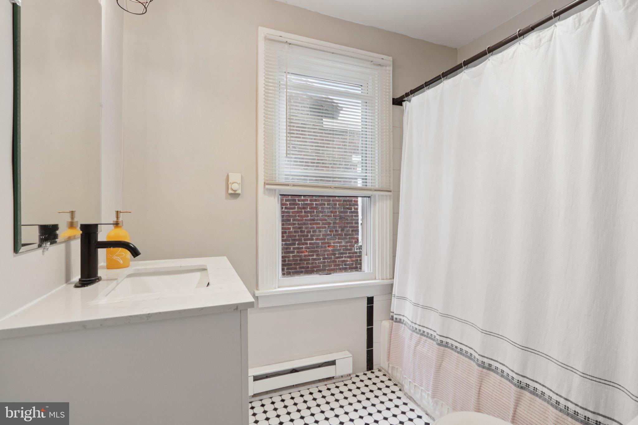 418 Walnut Street Pottstown, PA 19464 - Photo 31 of 52 a bathroom with a sink a mirror and a shower